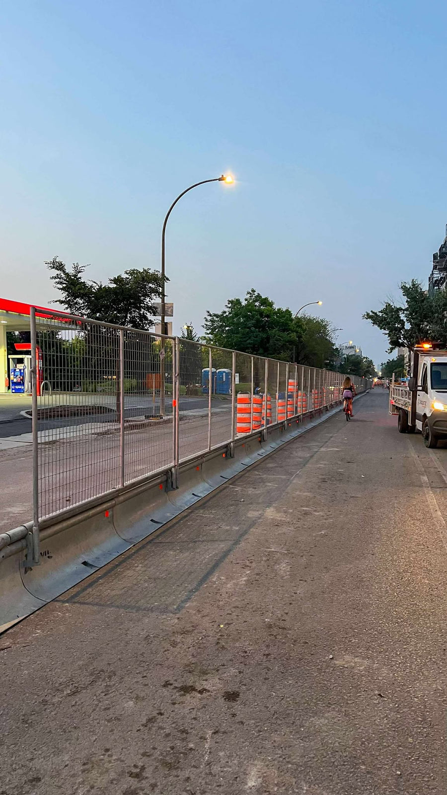 Clôture de chantier fixée sur des glissières Jersey le long d'une rue